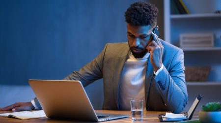 young-african-american-businessman-making-phone-call-indoors-in-office-at-night.jpg